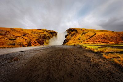 Scenic view of waterfall against sky