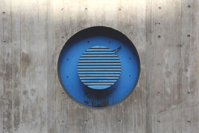 Blue circular metal on wooden wall