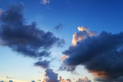 Low angle view of sunlight streaming through clouds