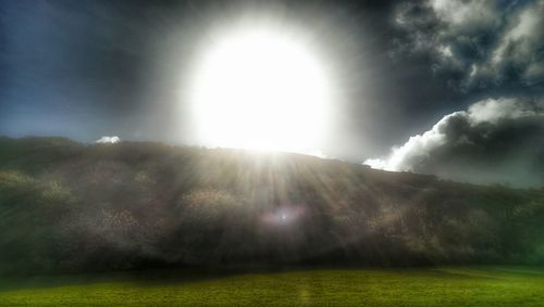 Scenic view of grassy field against sky