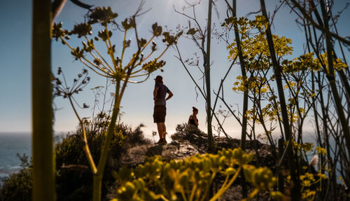 Man and woman standing by sea against sky