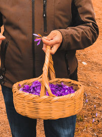 Midsection of man holding purple while standing outdoors