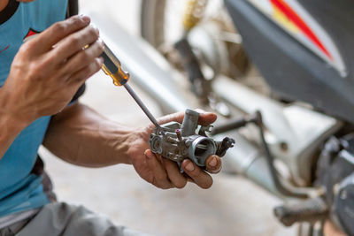 Midsection of man repairing car