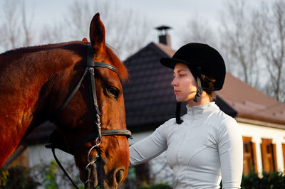 Portrait of woman with horse standing on field