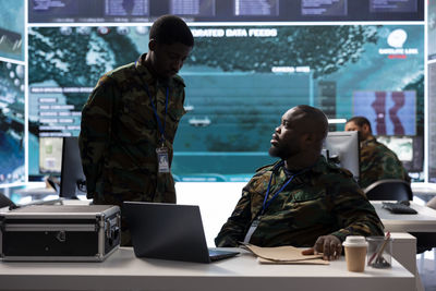 Rear view of man using mobile phone in cafe