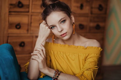 Portrait of young woman sitting at home