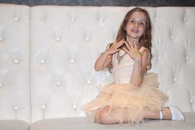 Portrait of smiling girl sitting on floor