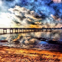 Pier on sea against cloudy sky