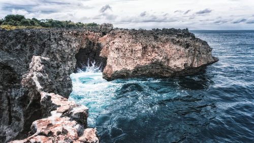 Rock formation in sea against sky