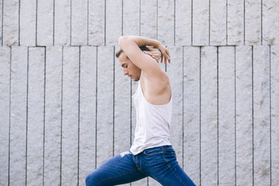 Side view of woman standing against wall