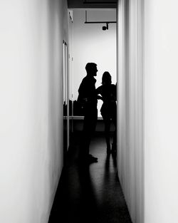 Silhouette friends standing in corridor at home