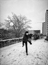 Full length of man on snow covered tree