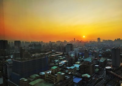 High angle view of illuminated buildings against sky during sunset