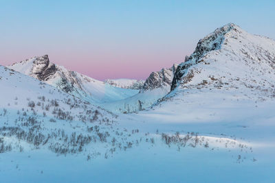 Scenic view of snow covered mountains against sky during sunset