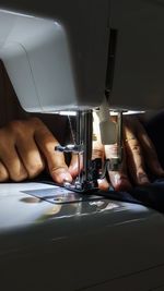 Cropped hand of person sewing with sewing machine
