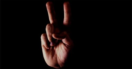 Close-up of human hand against black background