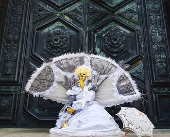 Person in costume sitting on floor against closed door