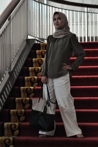 Portrait of woman standing on staircase