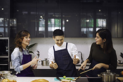 Smiling chefs preparing food in kitchen