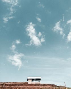 Low angle view of shed against cloudy sky