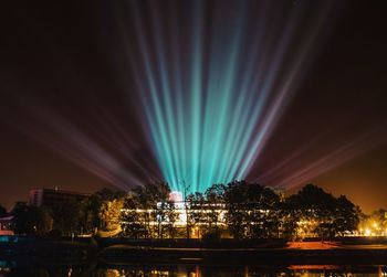 Illuminated cityscape against sky at night