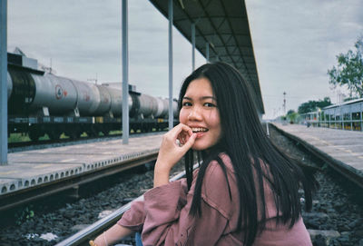 Portrait of smiling young woman on railway bridge