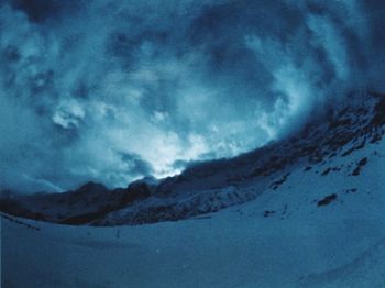 Scenic view of mountains against cloudy sky