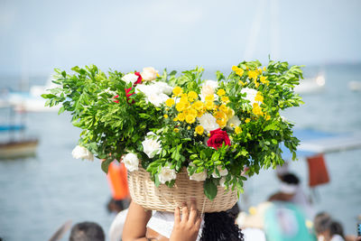 Candomble members are seen carrying a basket of flowers to offer to iemanja 