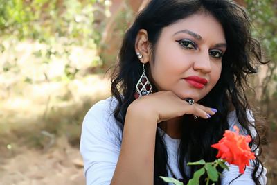 Close-up portrait of woman with orange flower