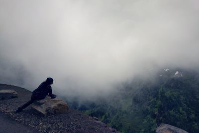 Female photographer looking at mountains and mist from a scenic vista in glacier national park.