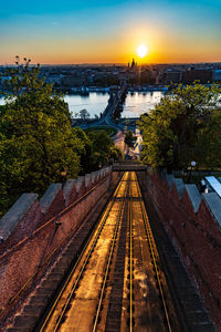 High angle view of railroad track against sky in city during sunset