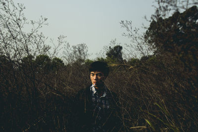 Man smoking while sitting amidst plants