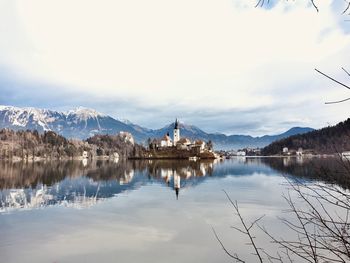 Scenic view of lake by snowcapped mountains against sky