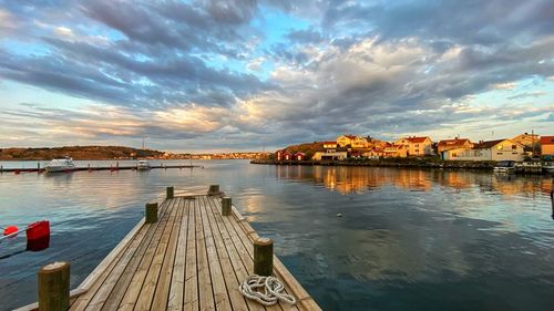 Pier over lake against sky during sunset