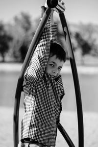 Boy hanging from play equipment