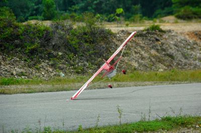 Red umbrella on land against lake