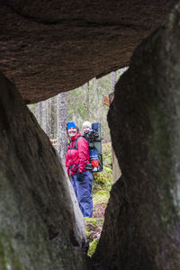 People on rock by tree trunk