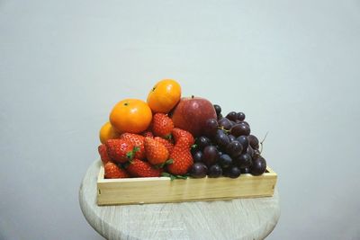 High angle view of fruits in plate against white background