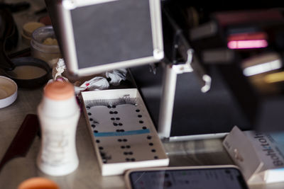 Selective focus false eyelashes on makeup artist table surrounded by many makeup 