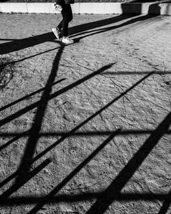 Low section of woman walking on shadow