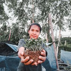 Portrait of woman holding plants