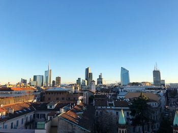 Modern buildings in city against clear blue sky