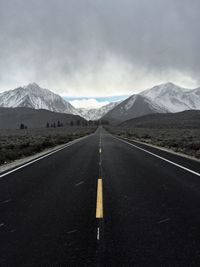 Empty road leading towards mountains