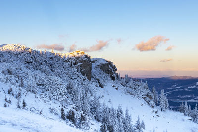 Snow covered landscape against sky