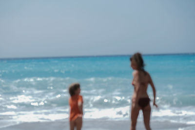 People at beach against sky