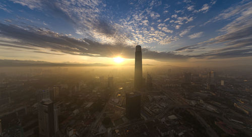 Aerial view of modern buildings against sky during sunset