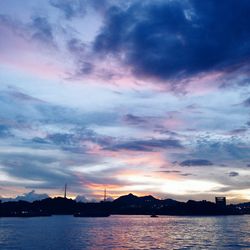 Scenic view of river against cloudy sky at sunset