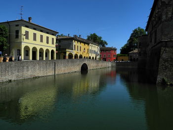 River in city against clear blue sky