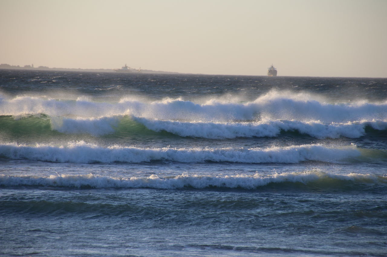 SCENIC VIEW OF WAVES SPLASHING ON SEA AGAINST SKY