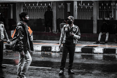 Full length of man with umbrella standing in rain